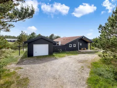 a black house with a white garage at Holiday Home Antto - 900m from the sea by Interhome in Torsted