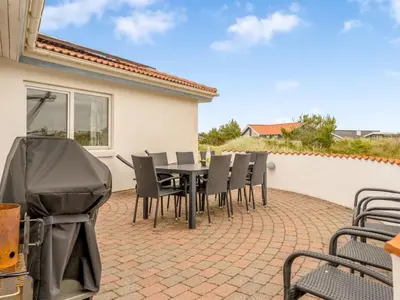 a patio with a black table and chairs at Holiday Home Palli - 600m from the sea by Interhome in Torsted