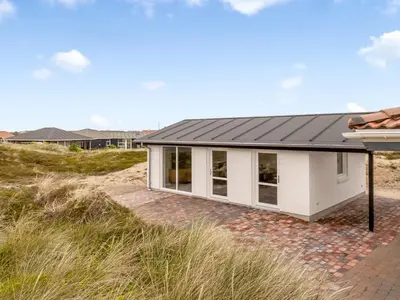 a house on the beach with a black roof at Holiday Home Palli - 600m from the sea by Interhome in Torsted