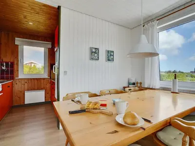 a kitchen and dining room with a wooden table at Holiday Home Usko - 250m from the sea by Interhome in Torsted