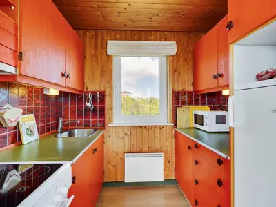 a kitchen with red cabinets and a window at Holiday Home Usko - 250m from the sea by Interhome in Torsted