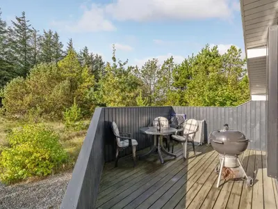 a patio with a table and a grill on a deck at Holiday Home Alethe - 1km from the sea by Interhome in Torsted