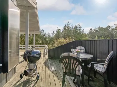 a grill and a table on a deck at Holiday Home Alethe - 1km from the sea by Interhome in Torsted