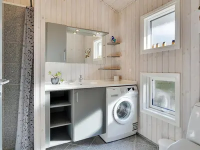 a bathroom with a washing machine and a sink at Holiday Home Alethe - 1km from the sea by Interhome in Torsted