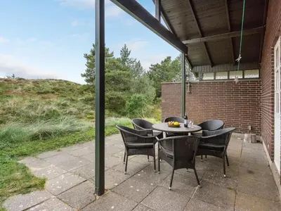 a patio with a table and chairs on a patio at Holiday Home Thermet - 900m from the sea by Interhome in Torsted