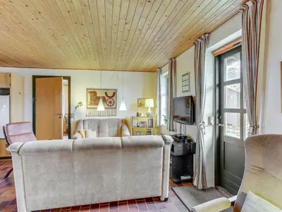 a living room with a couch and a tv at Holiday Home Thermet - 900m from the sea by Interhome in Torsted