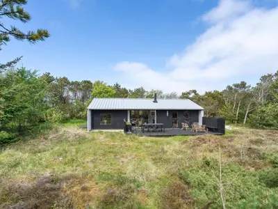 a small black house on a grassy field at Holiday Home Fidelia - 800m from the sea by Interhome in Torsted