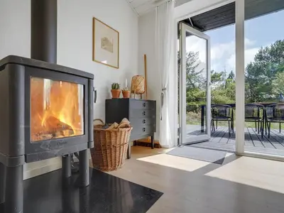 a fireplace in a living room with a patio at Holiday Home Fidelia - 800m from the sea by Interhome in Torsted