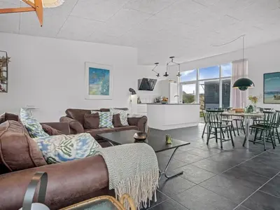 a living room with a couch and a table with chairs at Holiday Home Pontus - 400m from the sea by Interhome in Torsted