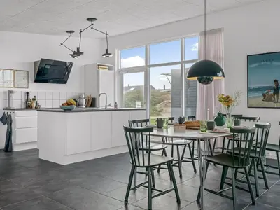 a kitchen and dining room with a table and chairs at Holiday Home Pontus - 400m from the sea by Interhome in Torsted