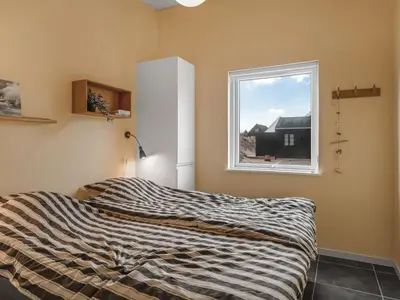 a bedroom with a bed and a window at Holiday Home Pontus - 400m from the sea by Interhome in Torsted