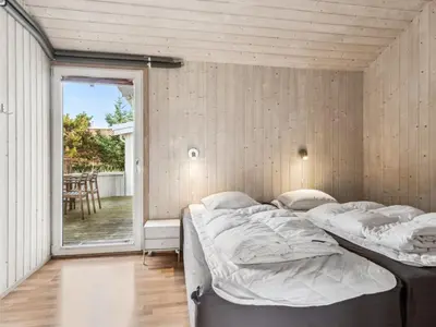 two beds in a room with a window at Holiday Home Zoya - 900m from the sea by Interhome in Torsted