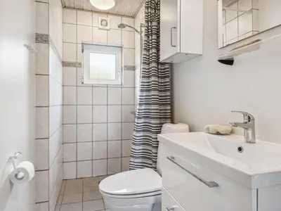 a white bathroom with a toilet and a sink at Holiday Home Zoya - 900m from the sea by Interhome in Torsted