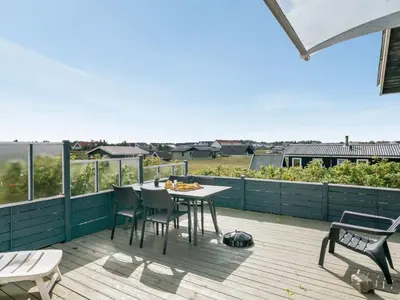 a patio with a table and chairs on a deck at Holiday Home Stener - 250m from the sea by Interhome in Torsted
