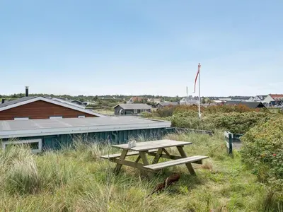 a picnic table in the grass next to a building at Holiday Home Stener - 250m from the sea by Interhome in Torsted