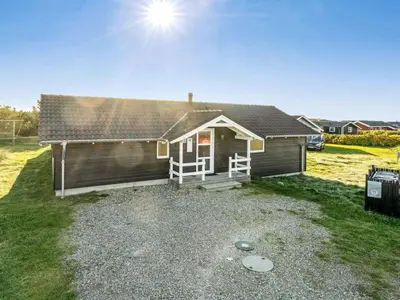 a small house with the sun in the sky at Holiday Home Horsten - 350m from the sea by Interhome in Torsted