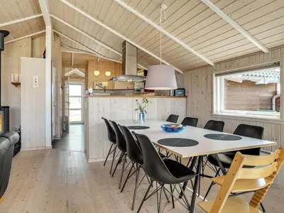 a kitchen and dining room with a table and chairs at Holiday Home Horsten - 350m from the sea by Interhome in Torsted
