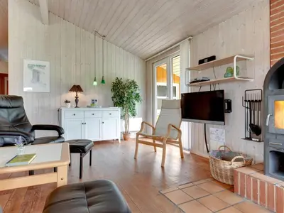 a living room with a couch and a tv at Holiday Home Annemia - 200m from the sea by Interhome in Torsted