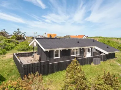 a black house with a black roof on a field at Holiday Home Gerlis - 75m from the sea by Interhome in Torsted