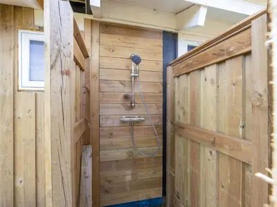 a bathroom with a shower in a wooden wall at Holiday Home Gerlis - 75m from the sea by Interhome in Torsted