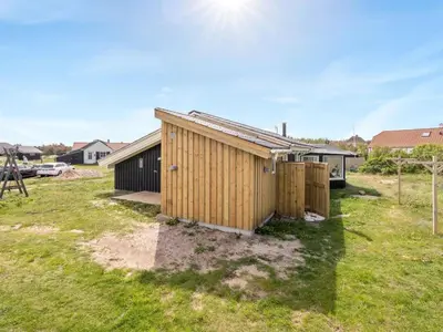 a small wooden building in a yard with grass at Holiday Home Gerlis - 75m from the sea by Interhome in Torsted