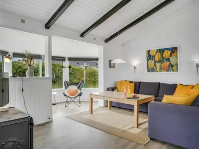 a living room with a blue couch and a table at Holiday Home Gerlis - 75m from the sea by Interhome in Torsted