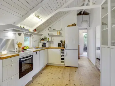 a kitchen with white cabinets and a white refrigerator at Holiday Home Tameran - 700m from the sea by Interhome in Torsted