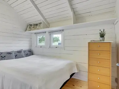 a white bedroom with a bed and two windows at Holiday Home Tameran - 700m from the sea by Interhome in Torsted