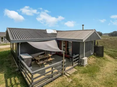 a small cabin with a roof on a field at Holiday Home Chumani - 900m from the sea by Interhome in Torsted