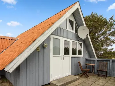 a grey shed with an orange roof and a white door at Holiday Home Algonda - 500m from the sea by Interhome in Torsted