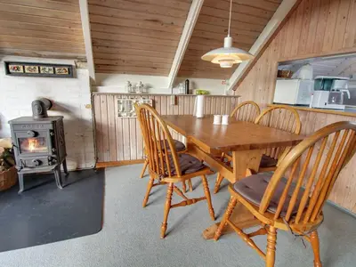 a dining room with a table and a wood stove at Holiday Home Algonda - 500m from the sea by Interhome in Torsted