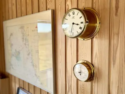 a clock on a wall next to a map at Holiday Home Bera - 250m from the sea by Interhome in Torsted
