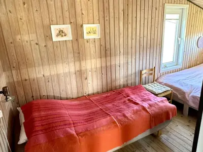 a bedroom with a bed with a red blanket at Holiday Home Bera - 250m from the sea by Interhome in Torsted