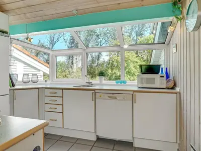 a kitchen with white cabinets and a window at Holiday Home Aslak - 350m from the sea by Interhome in Torsted
