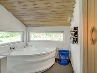 a white tub in a bathroom with a window at Holiday Home Aslak - 350m from the sea by Interhome in Torsted