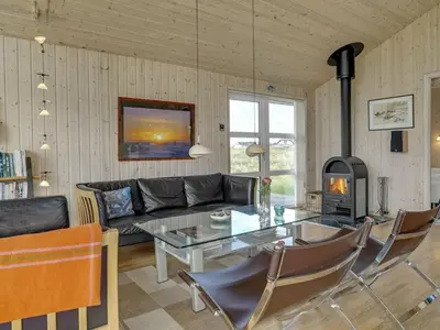 a living room with a table and a fireplace at Holiday Home Emppu - 400m from the sea by Interhome in Torsted
