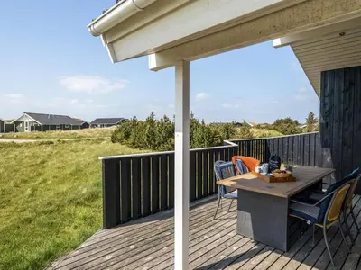 a patio with a table and chairs on a deck at Holiday Home Emppu - 400m from the sea by Interhome in Torsted