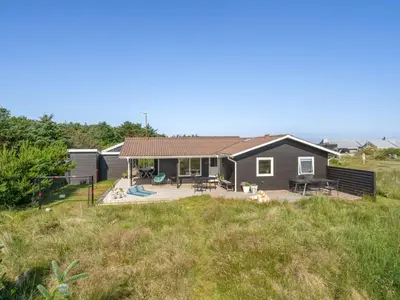 a house with a deck and a yard at Holiday Home Vuokko - 400m from the sea by Interhome in Torsted