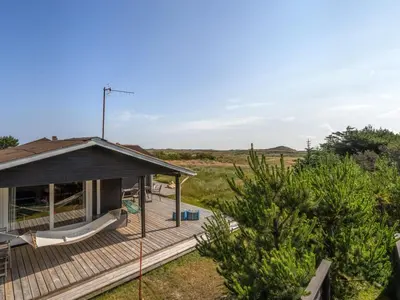 a house with a deck with a hammock on it at Holiday Home Vuokko - 400m from the sea by Interhome in Torsted