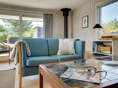 a living room with a blue couch and a table at Holiday Home Vuokko - 400m from the sea by Interhome in Torsted