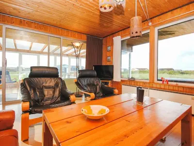 a living room with a wooden table and chairs at Holiday Home Gisela - 250m from the sea by Interhome in Torsted