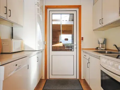 a kitchen with white cabinets and a white door at Holiday Home Gisela - 250m from the sea by Interhome in Torsted