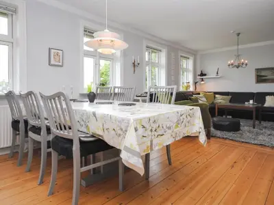 a dining room with a table with chairs and a couch at Holiday Home Ludovic - 7km from the sea by Interhome in Thisted