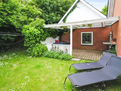 a backyard with a deck and a table and chairs at Holiday Home Ludovic - 7km from the sea by Interhome in Thisted