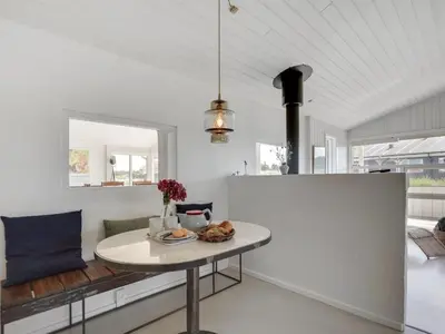 a white kitchen with a table in a room at Holiday Home Milena - 600m from the sea by Interhome in Torsted