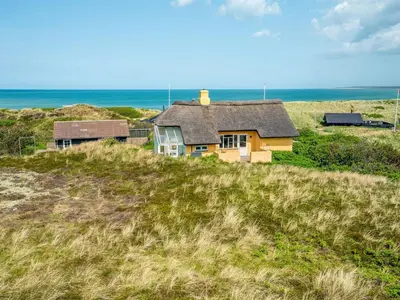 a house sitting on top of a grassy hill at Holiday Home Quirina - 75m from the sea by Interhome in Torsted