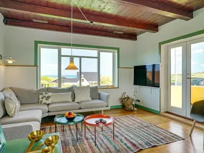 a living room with a couch and a tv at Holiday Home Quirina - 75m from the sea by Interhome in Torsted