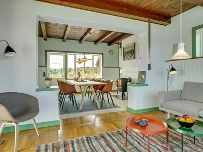 a living room with a table and a couch at Holiday Home Quirina - 75m from the sea by Interhome in Torsted