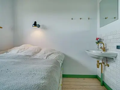 a bedroom with a bed and a sink at Holiday Home Quirina - 75m from the sea by Interhome in Torsted