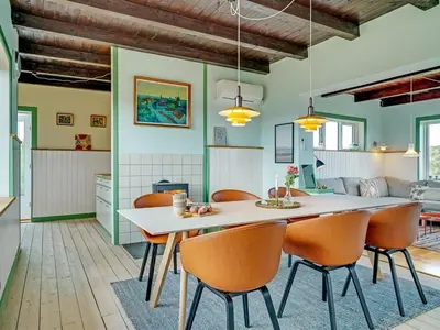 a kitchen and dining room with a table and chairs at Holiday Home Quirina - 75m from the sea by Interhome in Torsted